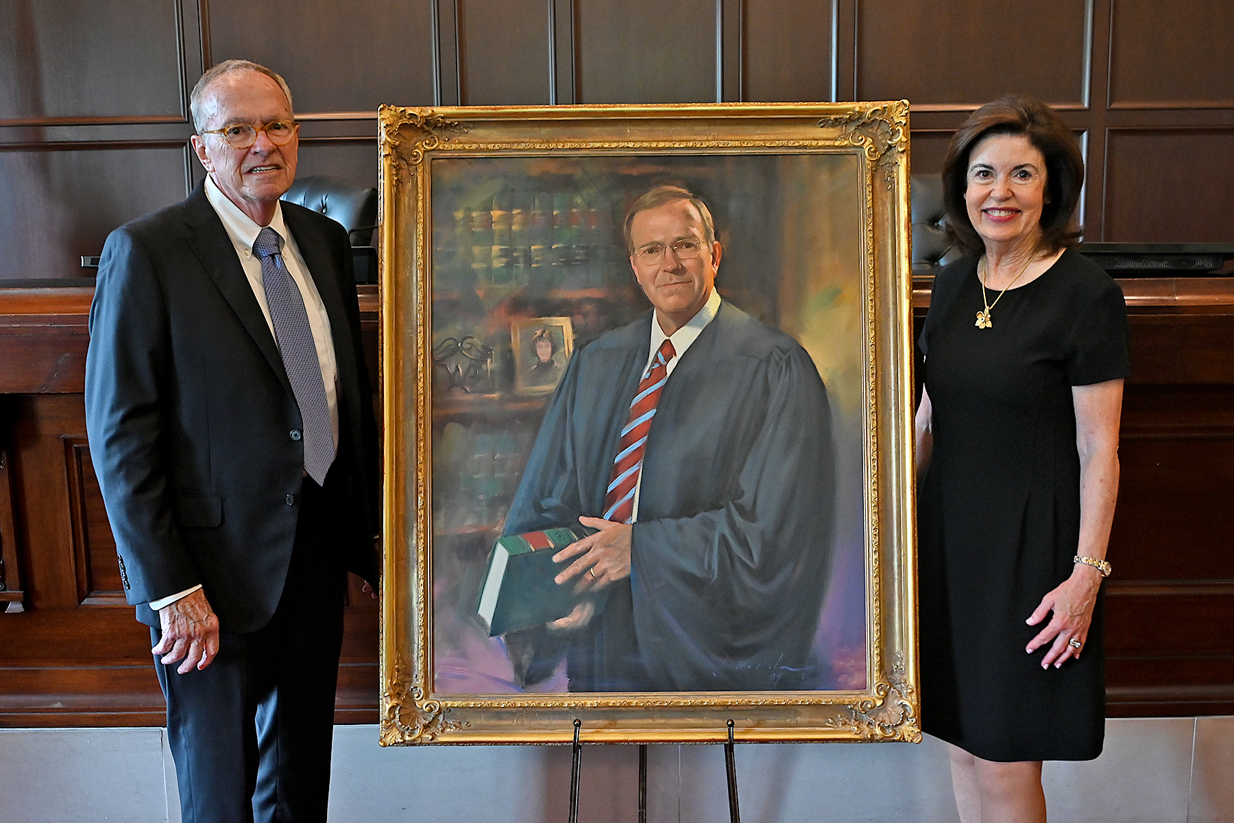 Former Chief Judge Martin (left) poses with his portrait along with his wife. 