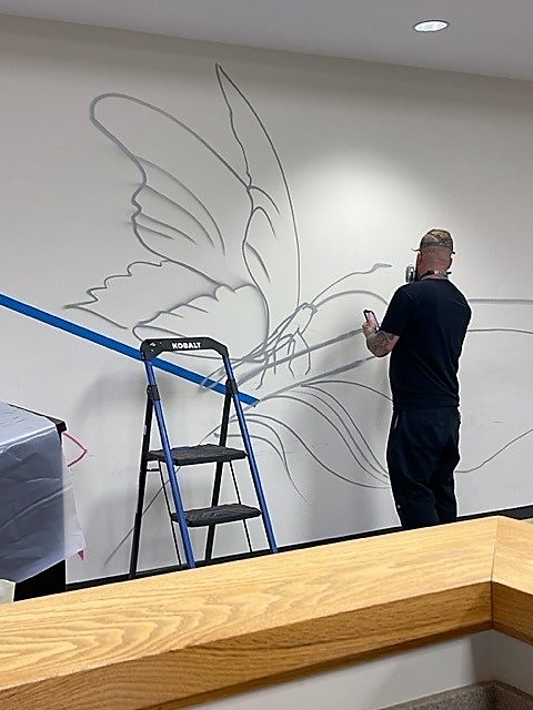 The artist begins the mural. 