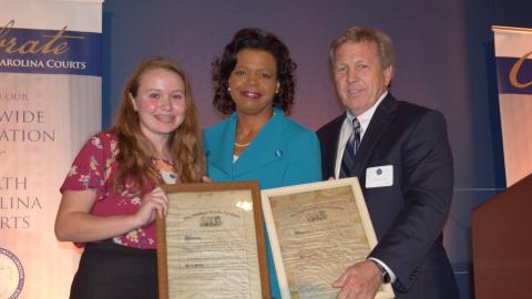Walter Holton (right) and Mary Holton (left) present Chief Justice Cheri Beasley with Tabitha Holton's law license (photo credit: North Carolina Bar Association)