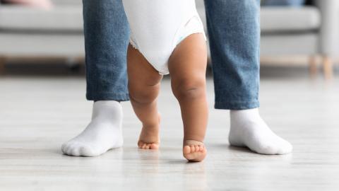 Baby legs with parent feet